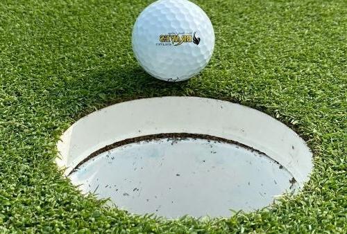 BHC Braves golf ball on edge of cup on the green